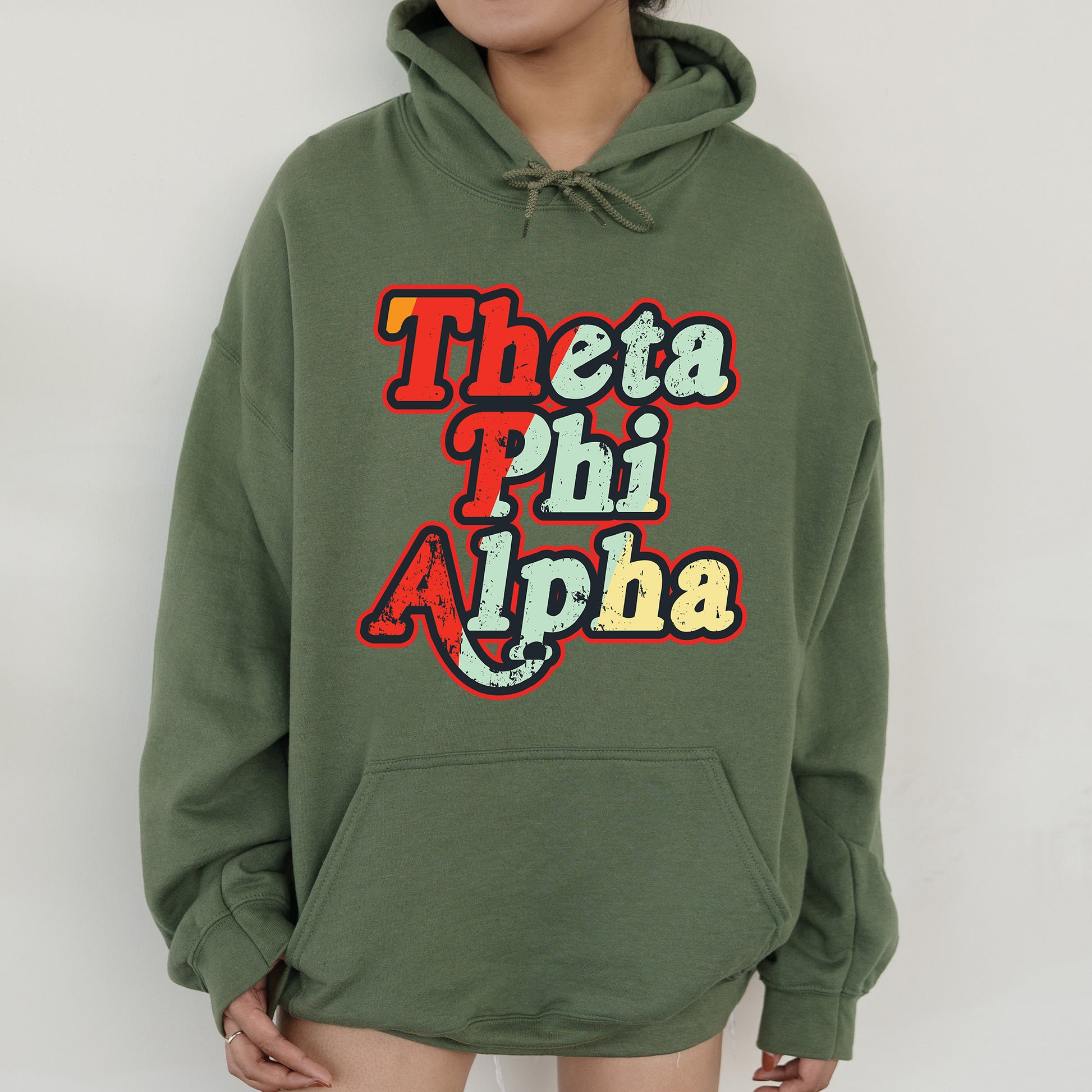 a person wearing a green hoodie with the words thea phi alpha on