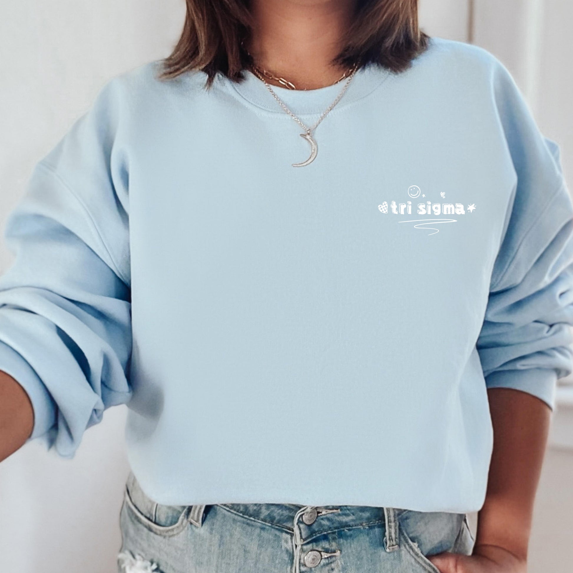 a woman wearing a light blue sweatshirt with a white slogan on it
