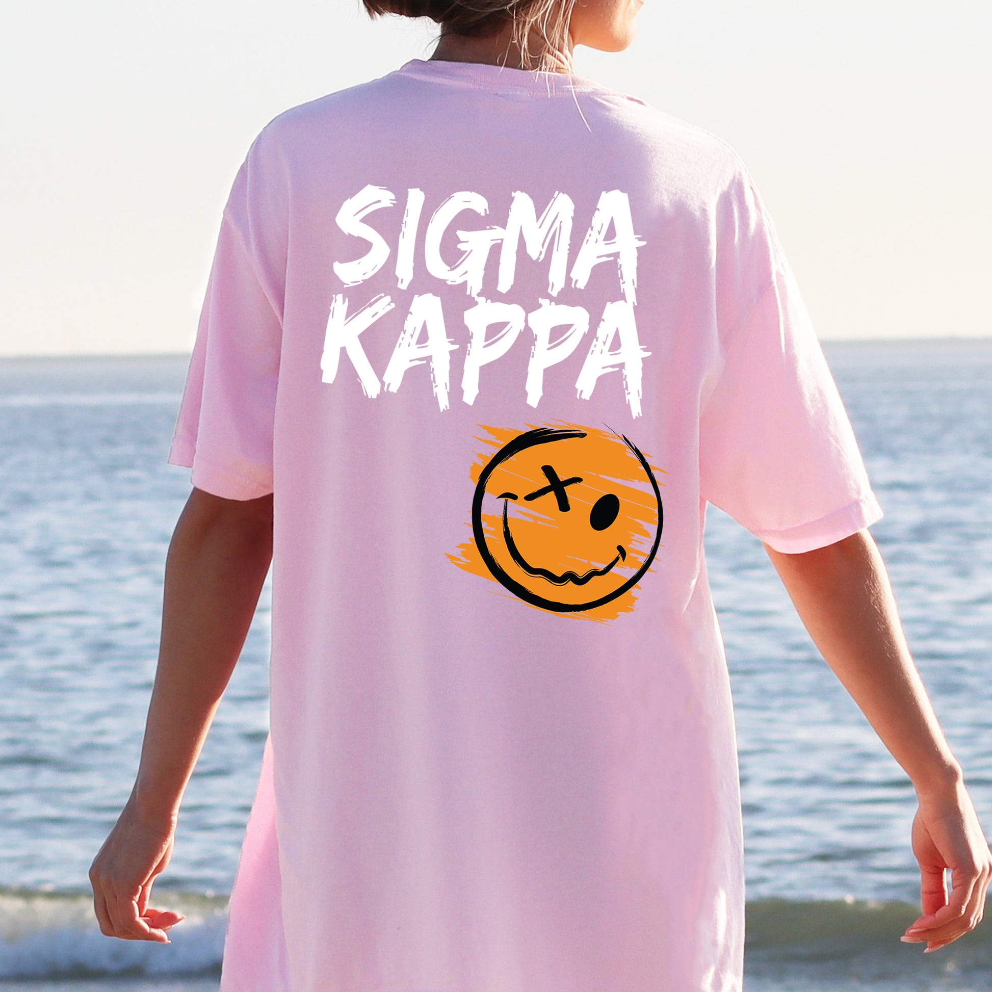 a person wearing a pink shirt with a smiley face on it