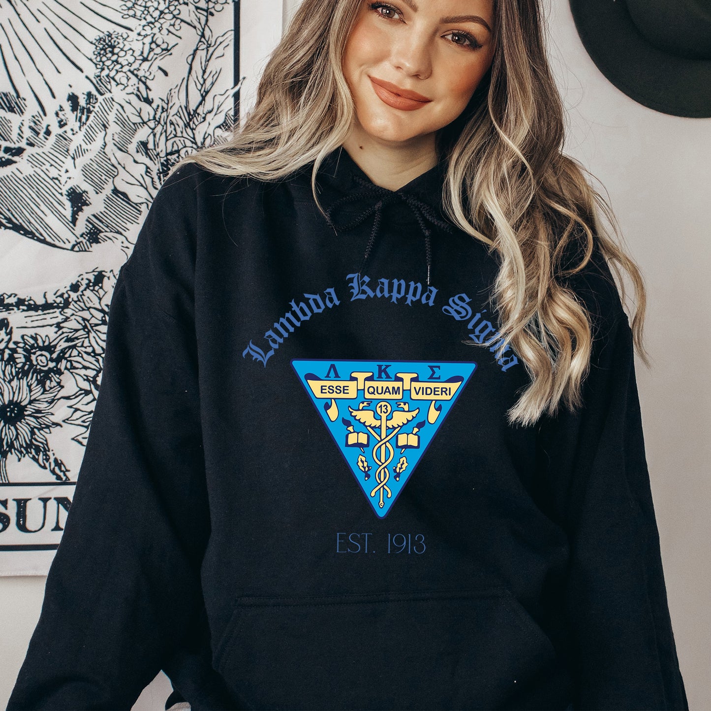 a woman wearing a black hoodie with a blue triangle on it