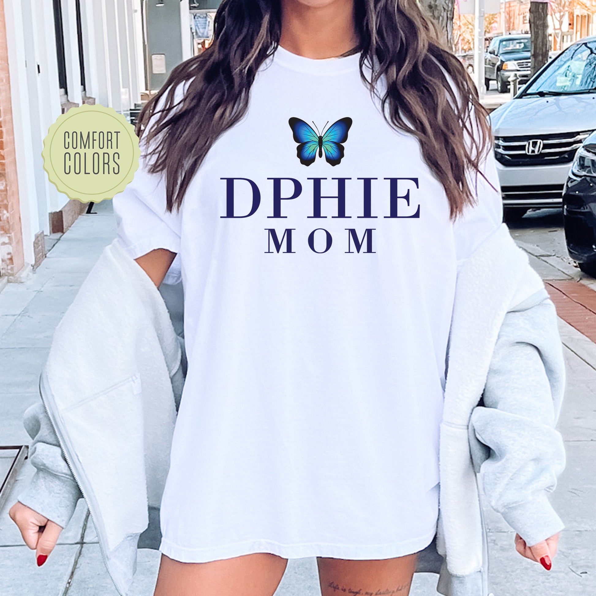 a woman wearing a white shirt with a blue butterfly on it