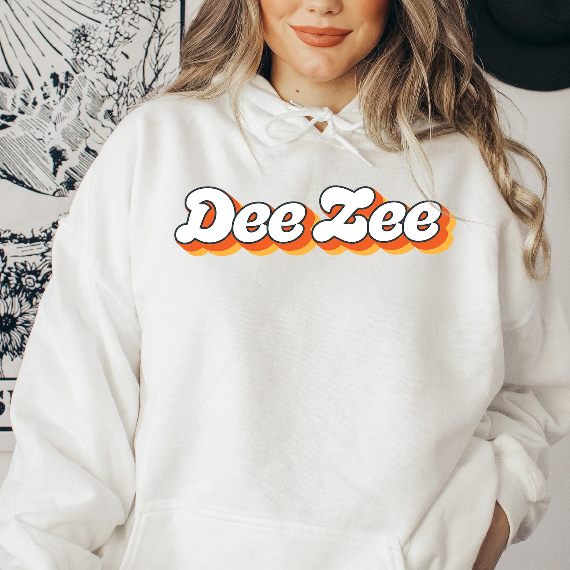 a woman wearing a white hoodie with the word dee zee on it