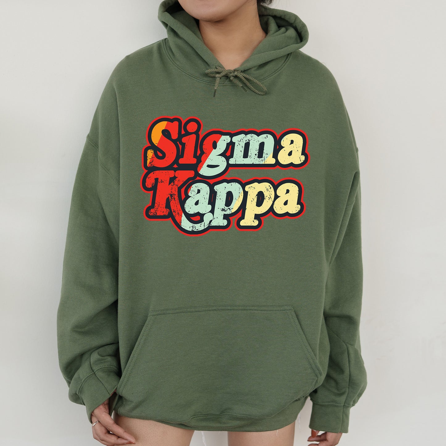 a woman wearing a green hoodie that says stigmaa kappa