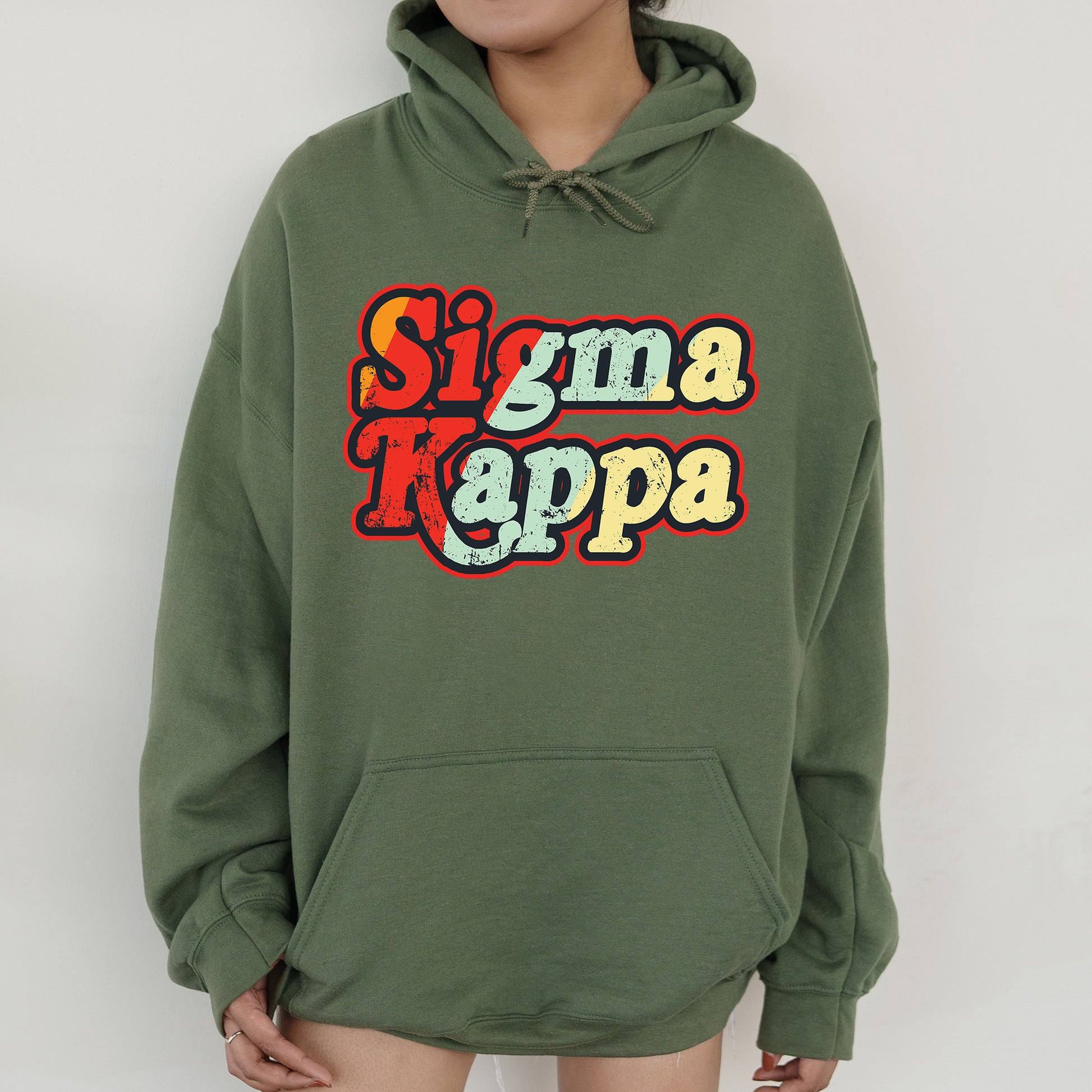 a woman wearing a green hoodie that says stigmaa kappa