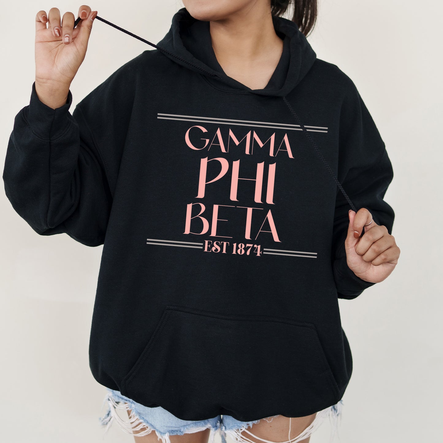a woman wearing a black hoodie with pink letters on it
