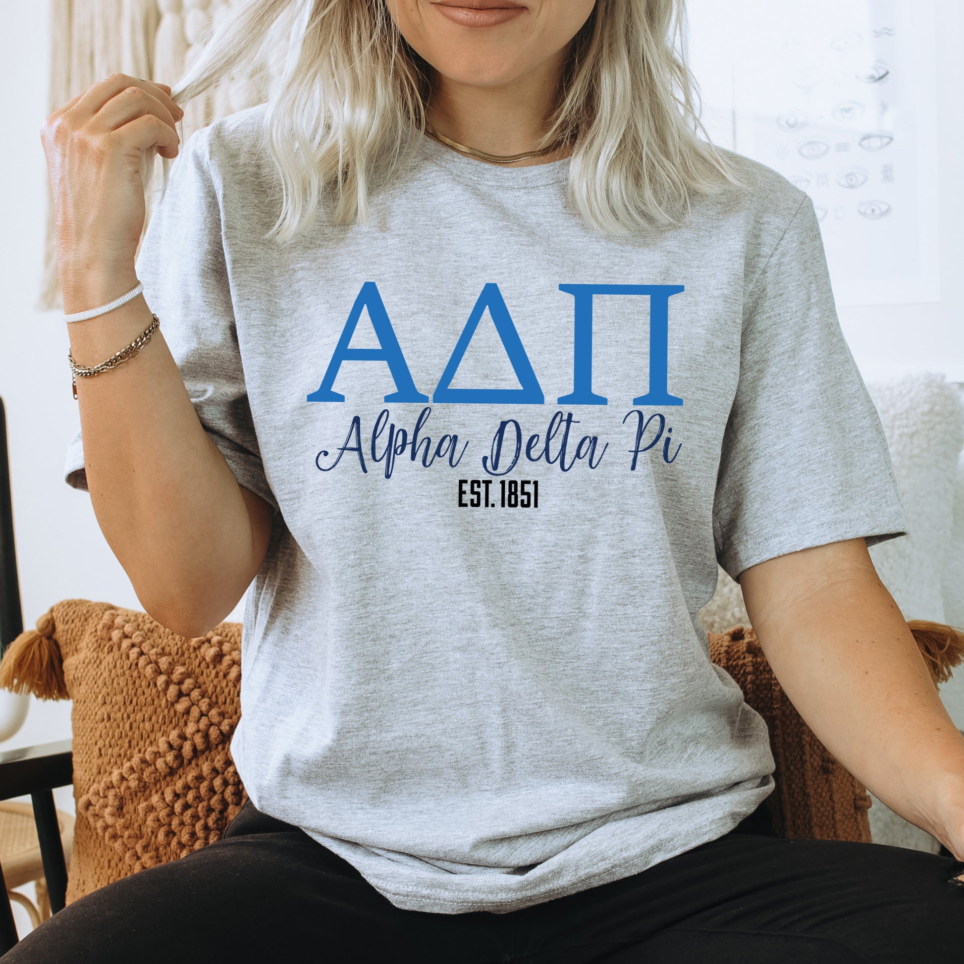 a woman sitting on a chair wearing a delta shirt