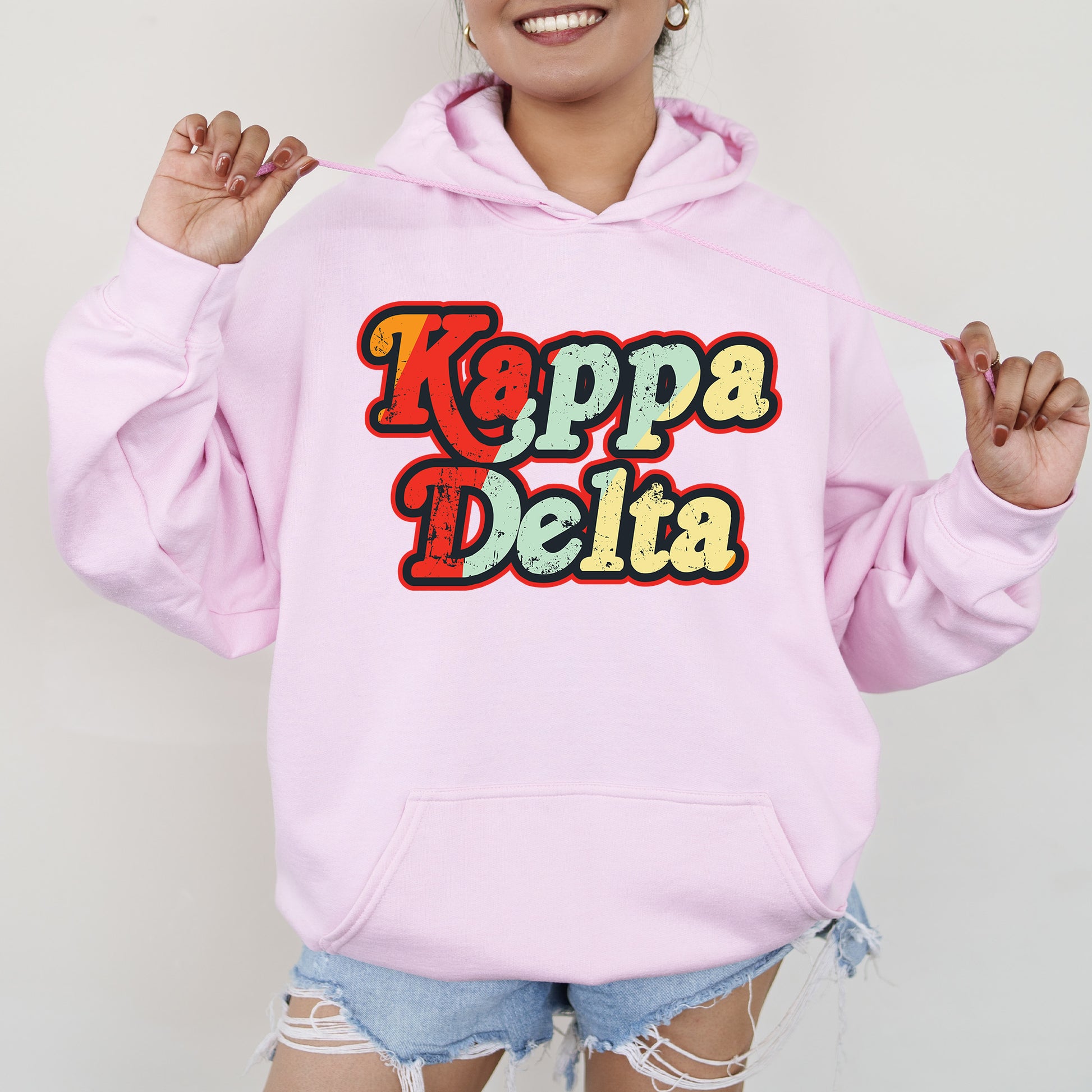 a woman wearing a pink hoodie that says kappa delta