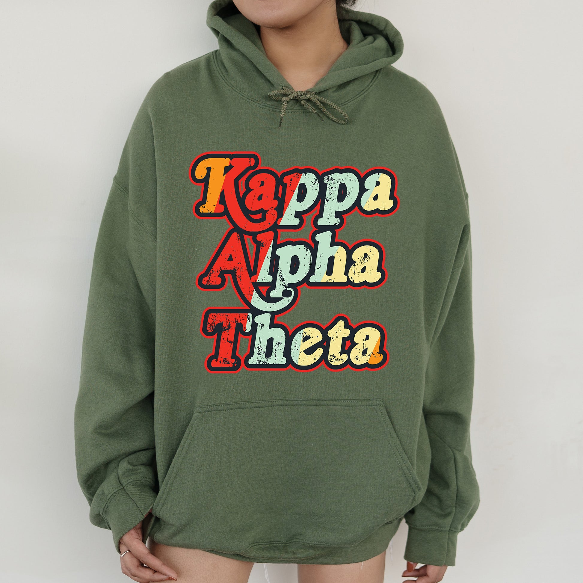 a woman wearing a green hoodie that says kappa alpha thea