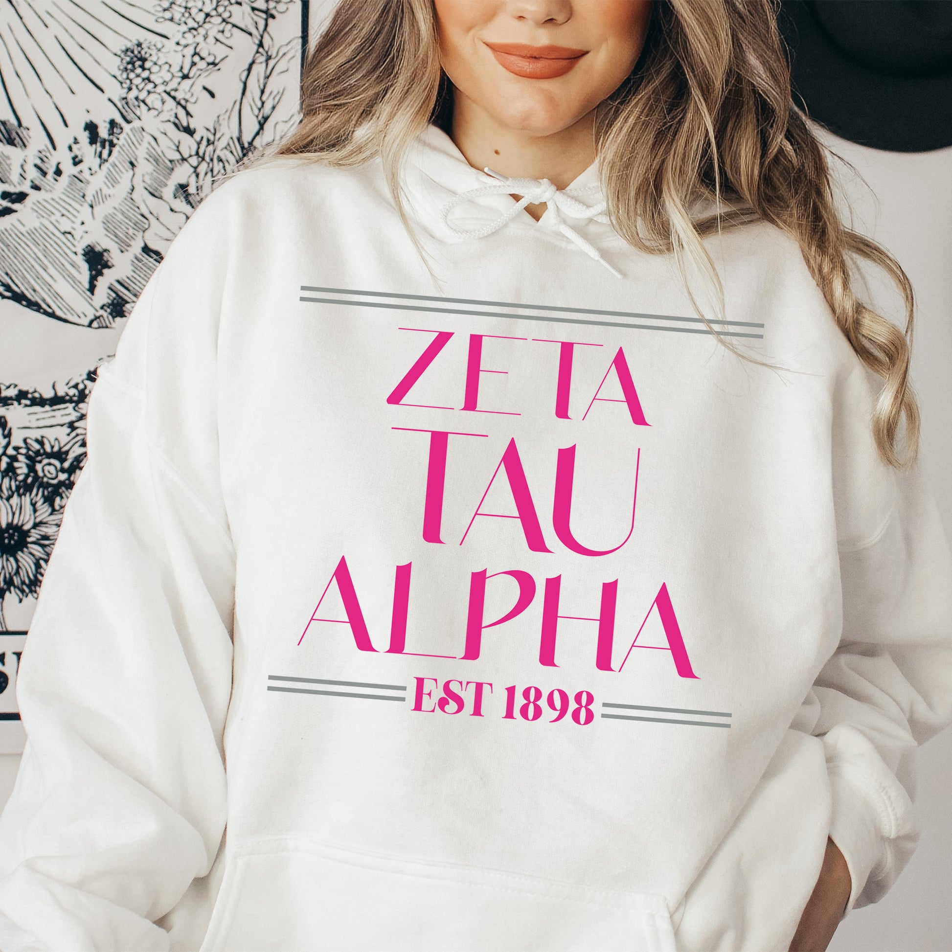 a woman wearing a white hoodie with pink letters on it