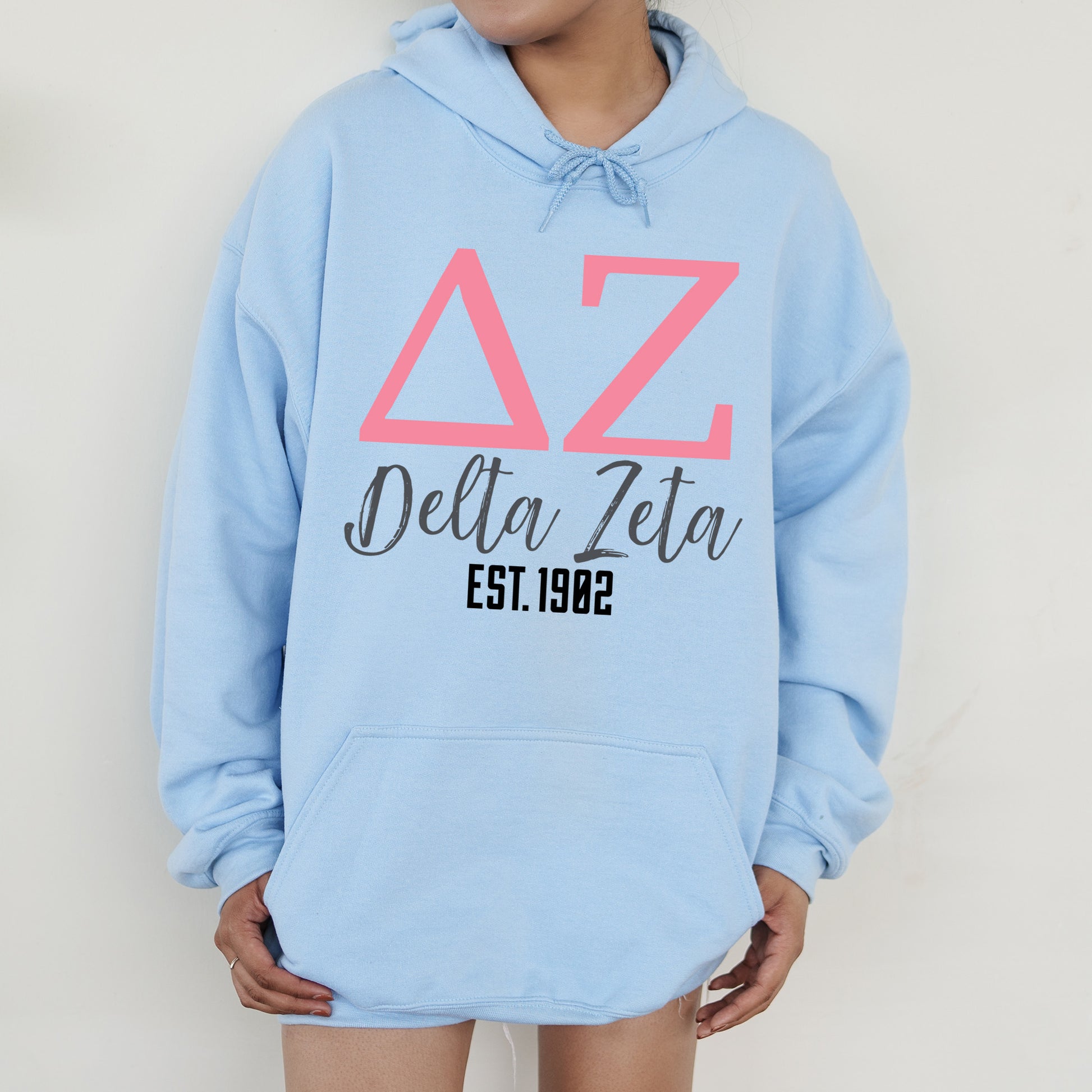 a woman wearing a blue hoodie with a delta delta on it