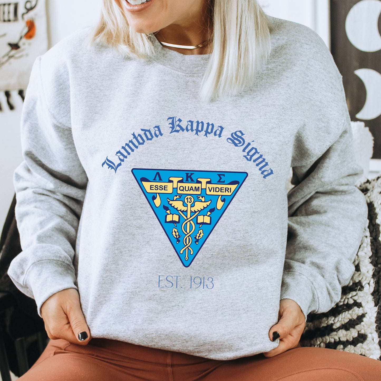 a woman sitting on a chair wearing a sweatshirt