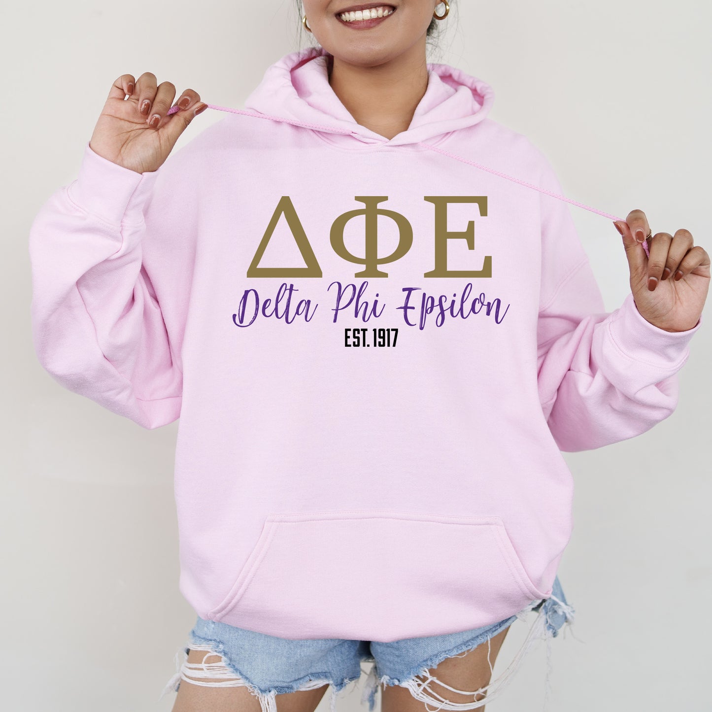 a woman wearing a pink hoodie that says delta phi epiloon