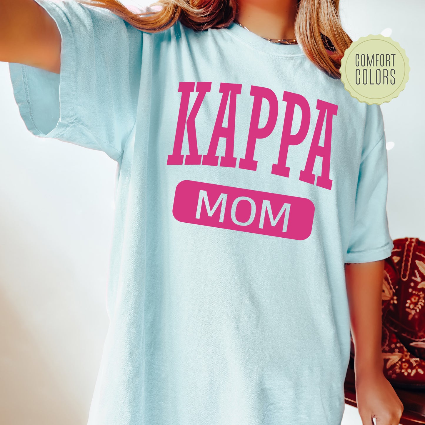 a woman wearing a t - shirt that says kappa mom
