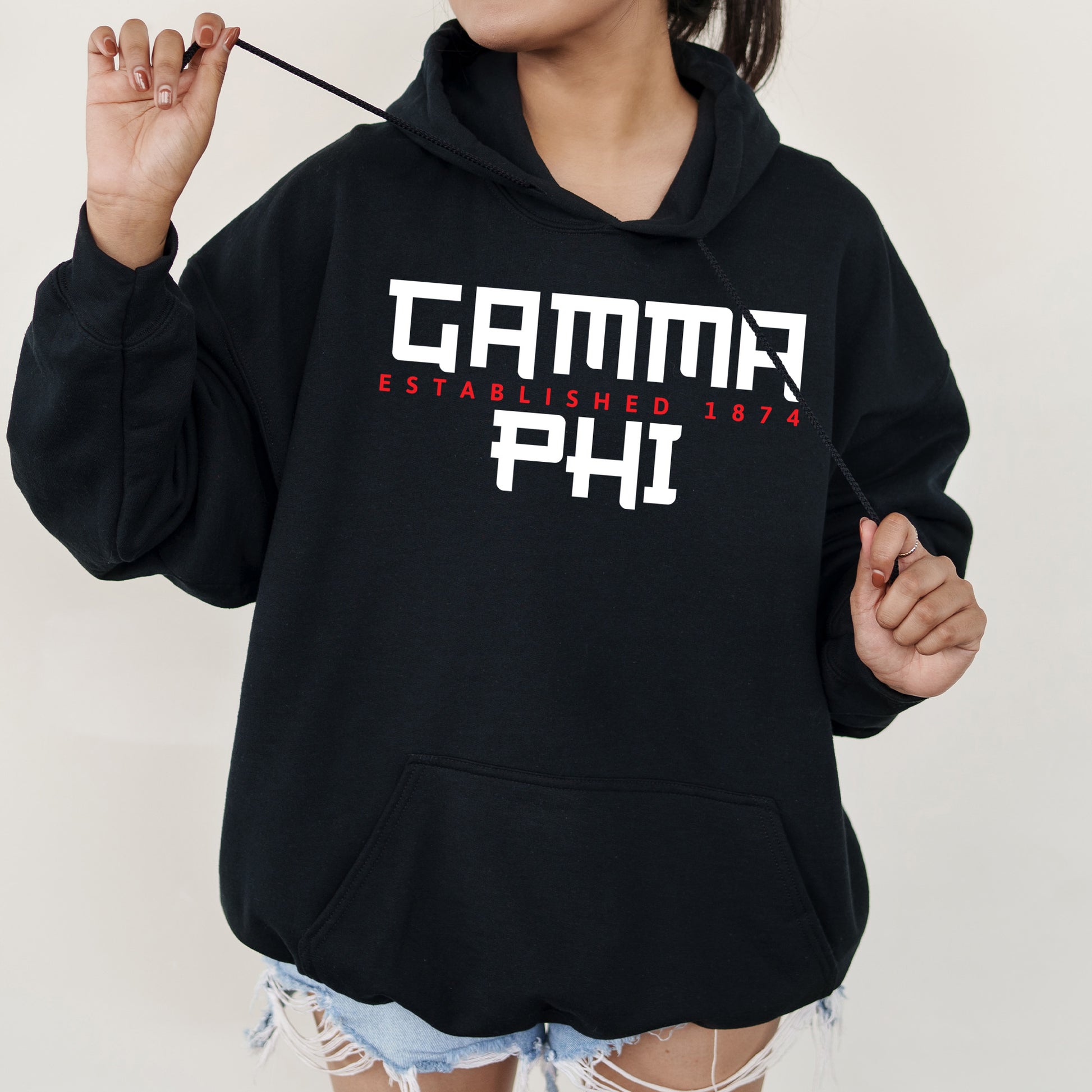 a woman in a black hoodie is holding a stick