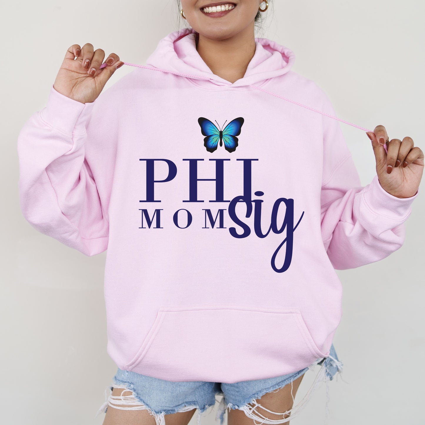 a woman wearing a pink hoodie with a butterfly on it