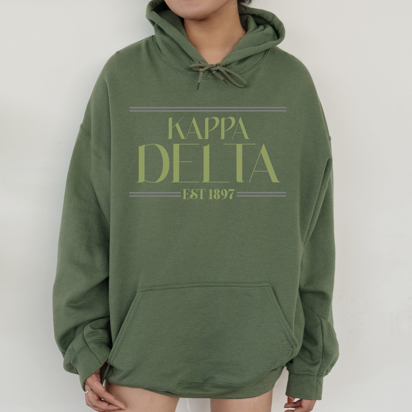 a woman wearing a green hoodie with the words kappa delta on it