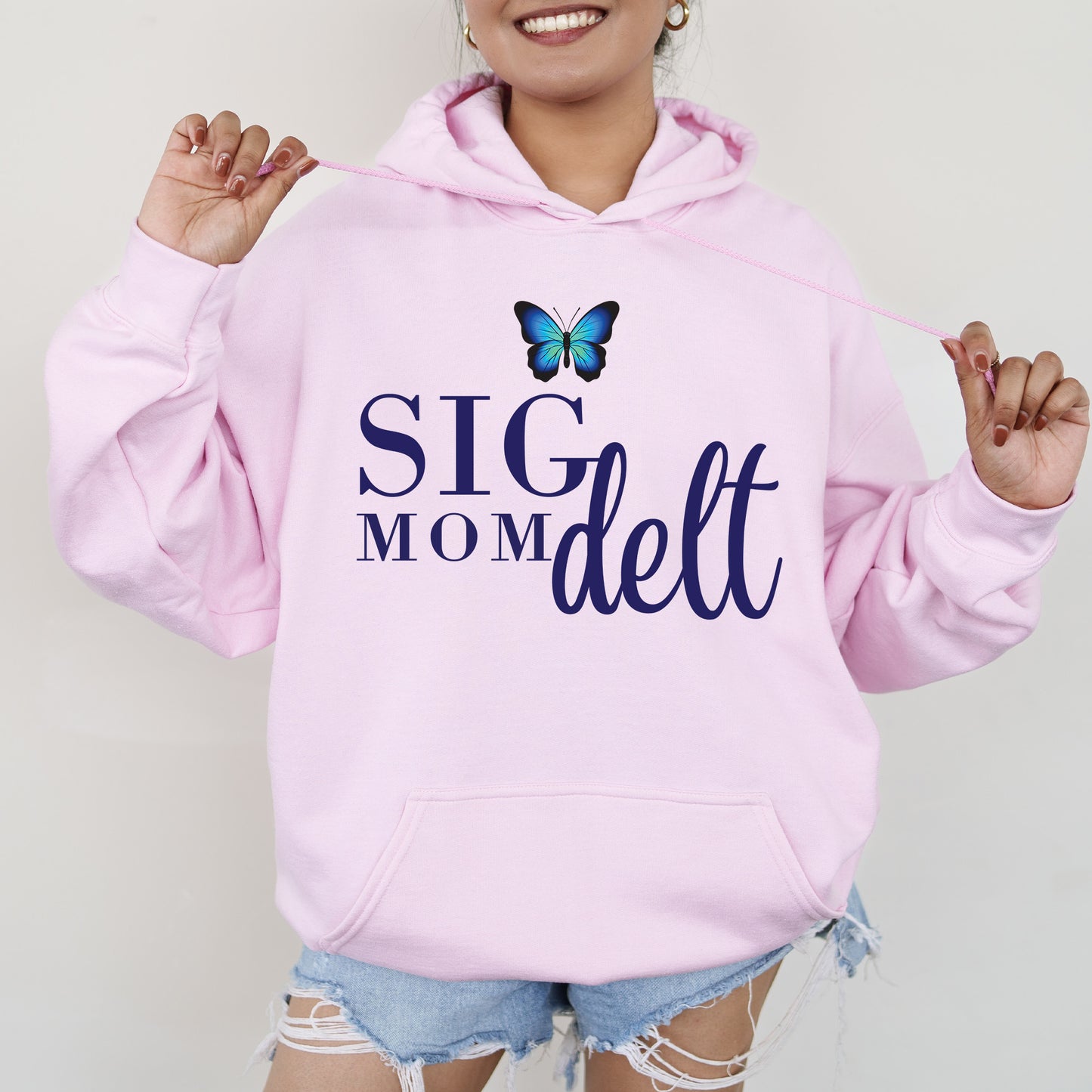 a woman wearing a pink hoodie with a butterfly on it