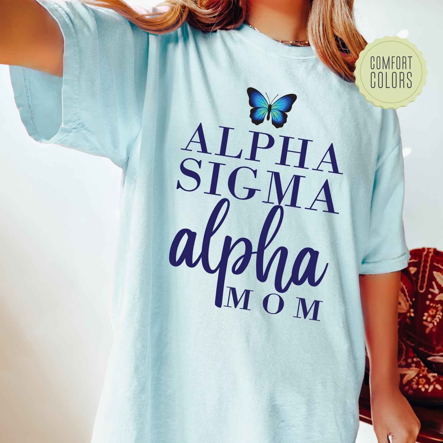 a young girl wearing a blue shirt with a butterfly on it