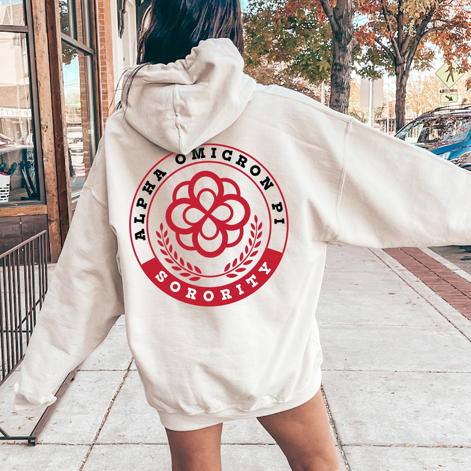 a woman in a white hoodie is walking down the street