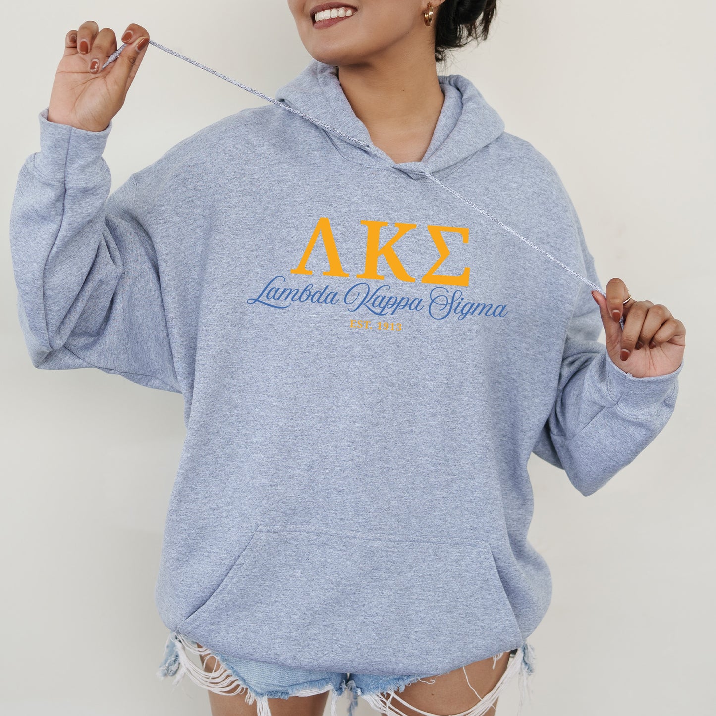 a woman in a blue hoodie holding a toothbrush
