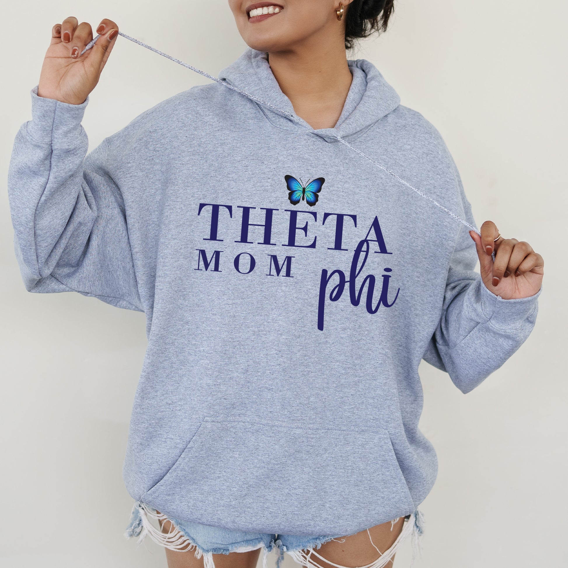 a woman in a blue hoodie holding a toothbrush