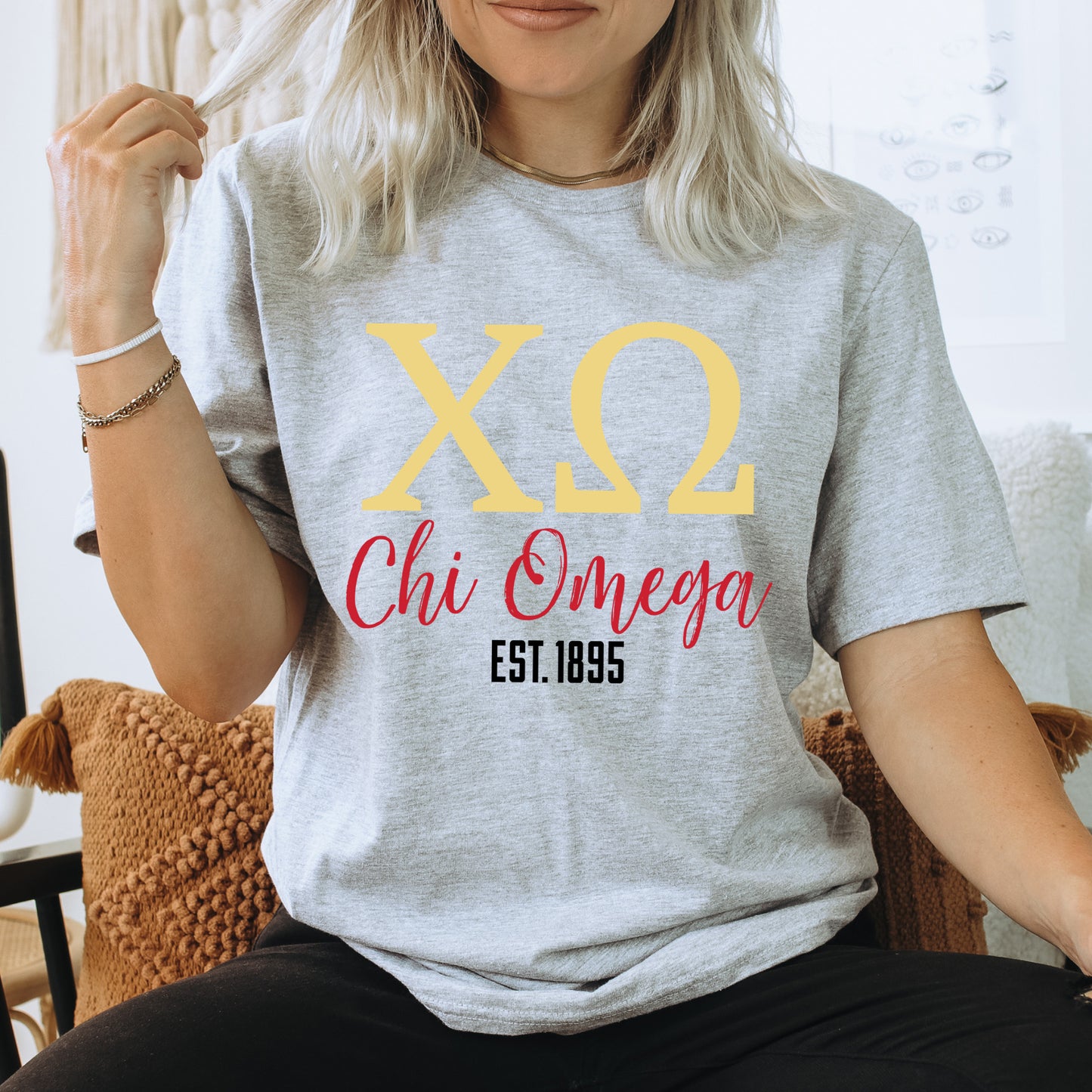 a woman sitting on a chair wearing a t - shirt that says xo chi