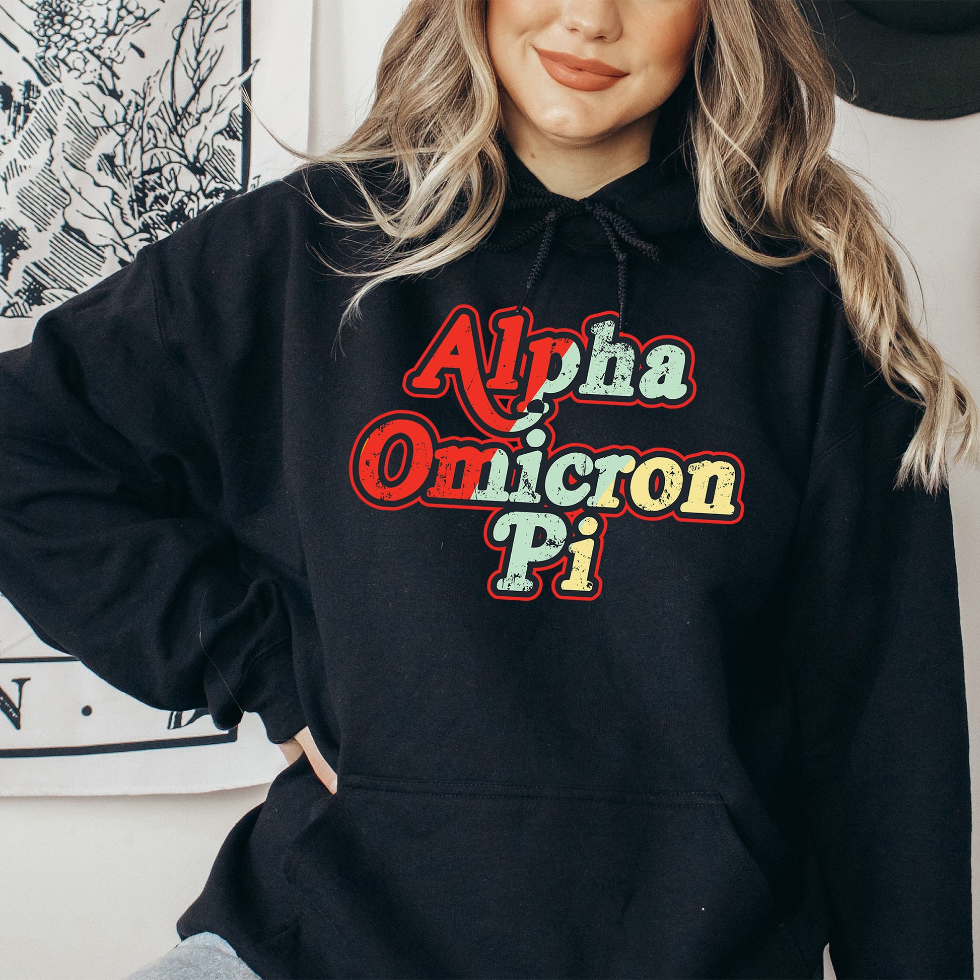 a woman wearing a black hoodie that says alpha omucron pi