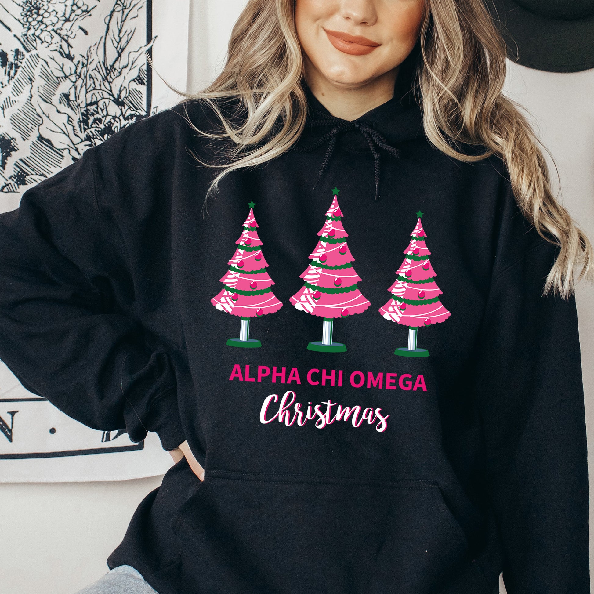 a woman wearing a black hoodie with pink christmas trees on it