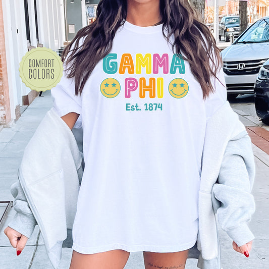 a woman wearing a white shirt with the words gama phi on it