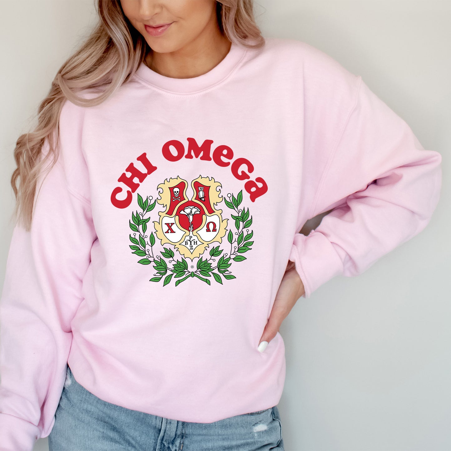 a woman wearing a pink sweatshirt with a crest on it