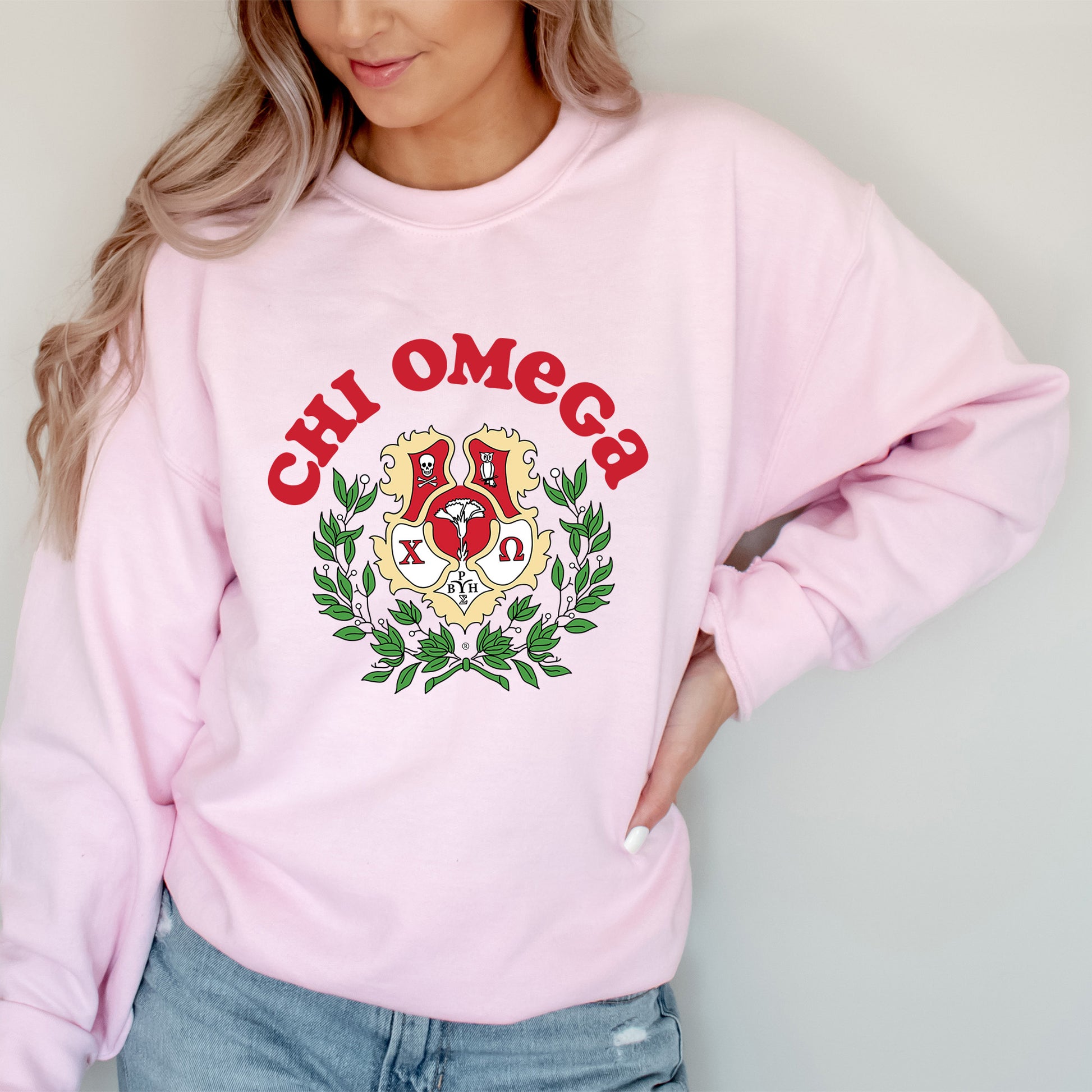 a woman wearing a pink sweatshirt with a crest on it