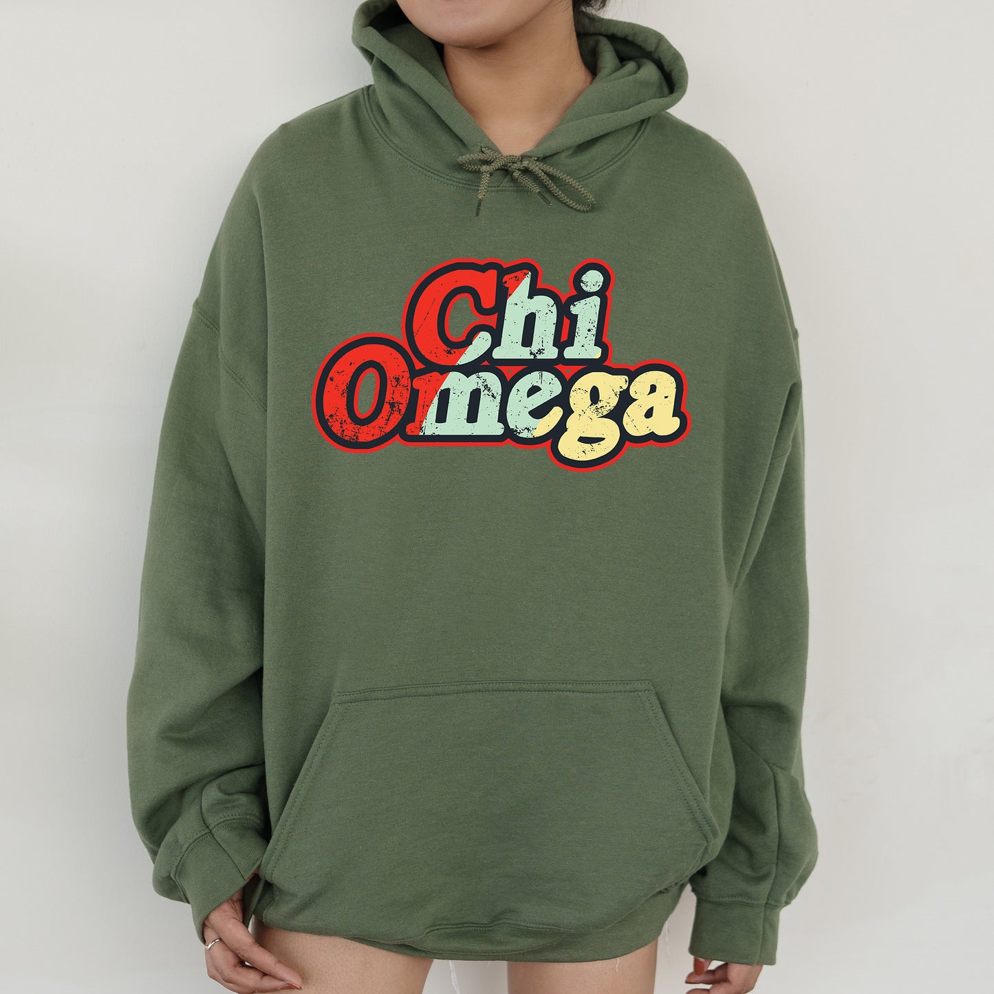 a woman wearing a green hoodie that says chi omega