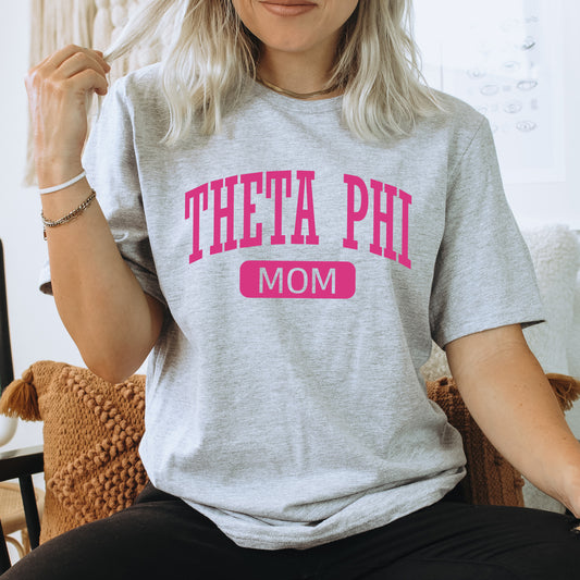 a woman sitting on a chair wearing a t - shirt that says thea phi