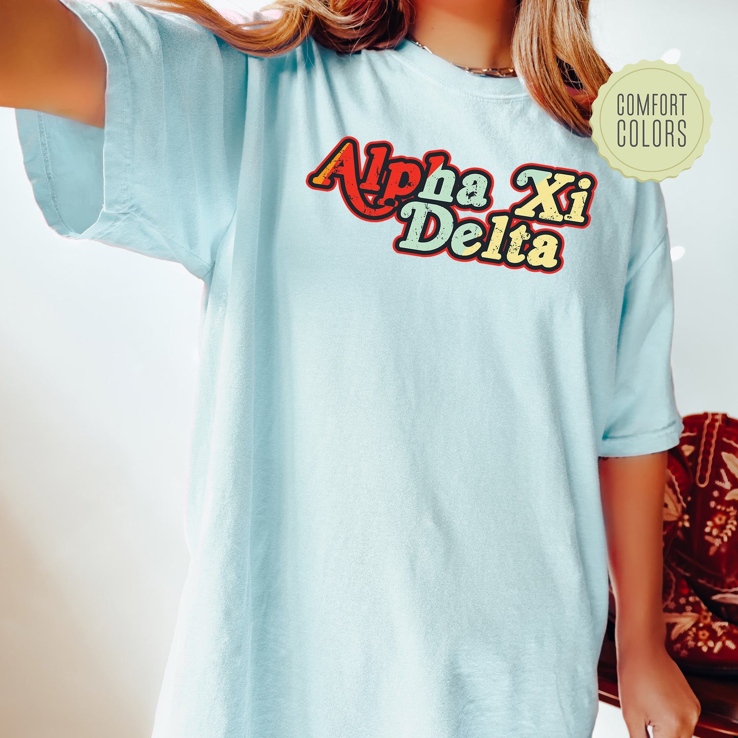 a woman wearing a light blue shirt with the word ahha xi delta on it