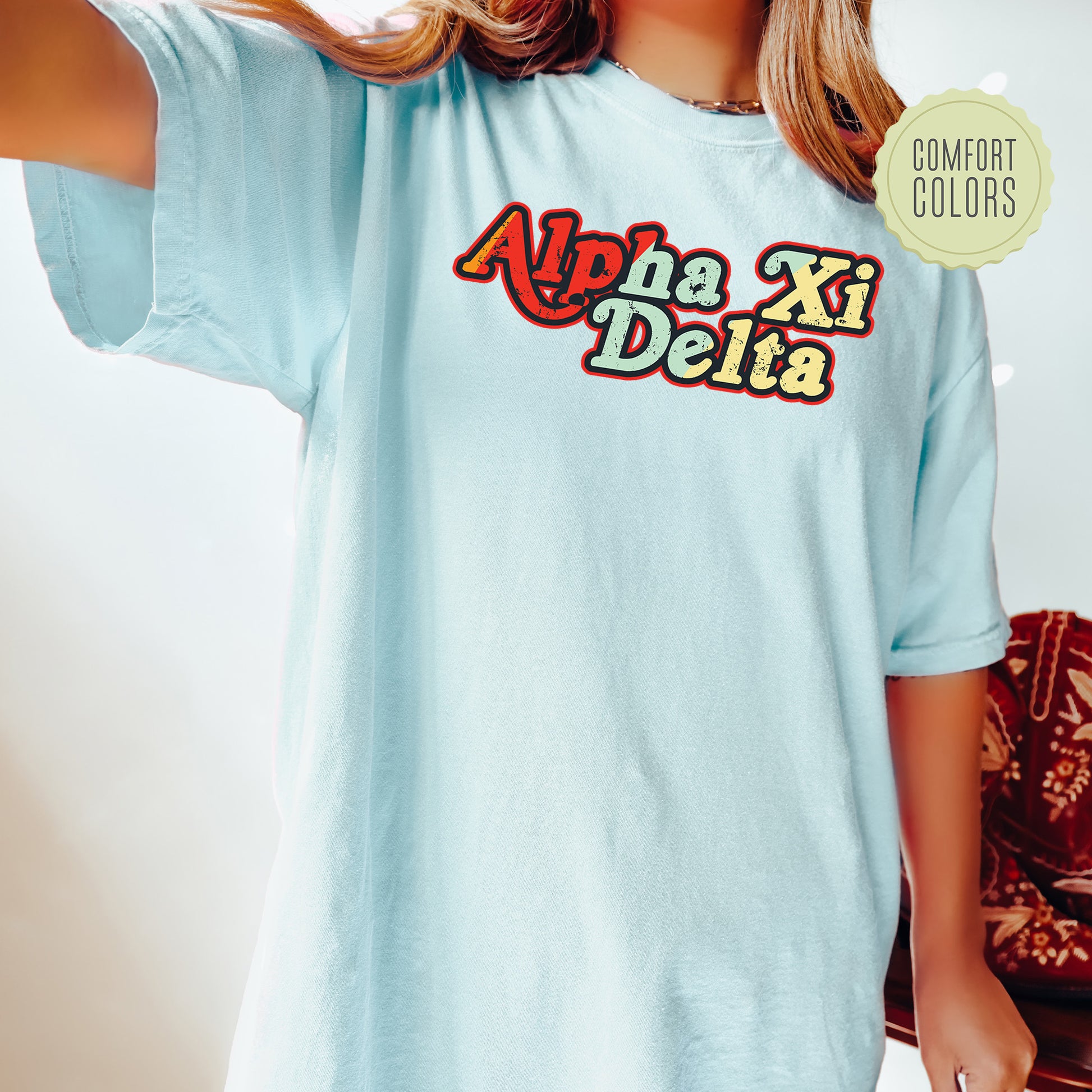 a woman wearing a light blue shirt with the word ahha xi delta on it