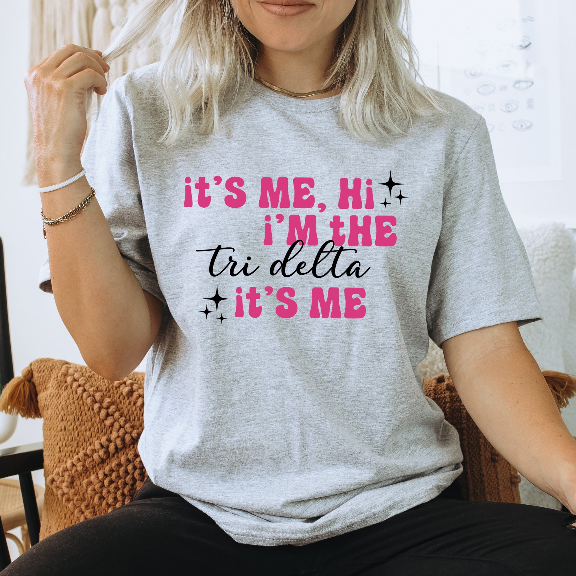 a woman sitting on a chair wearing a t - shirt that says it's
