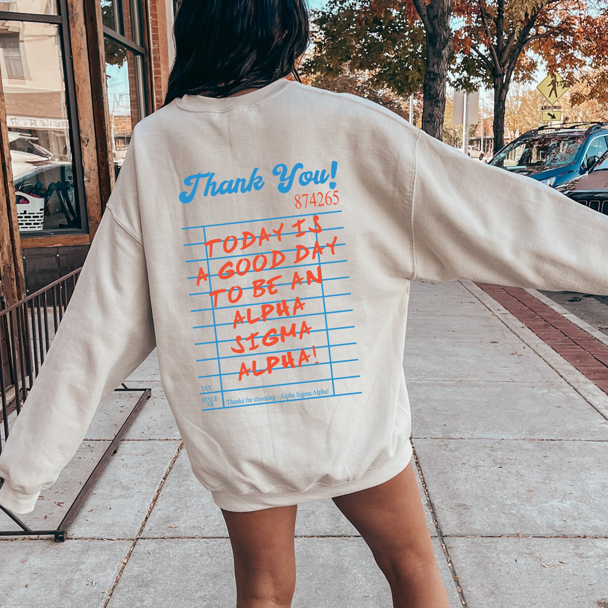 a woman walking down a sidewalk with her back to the camera