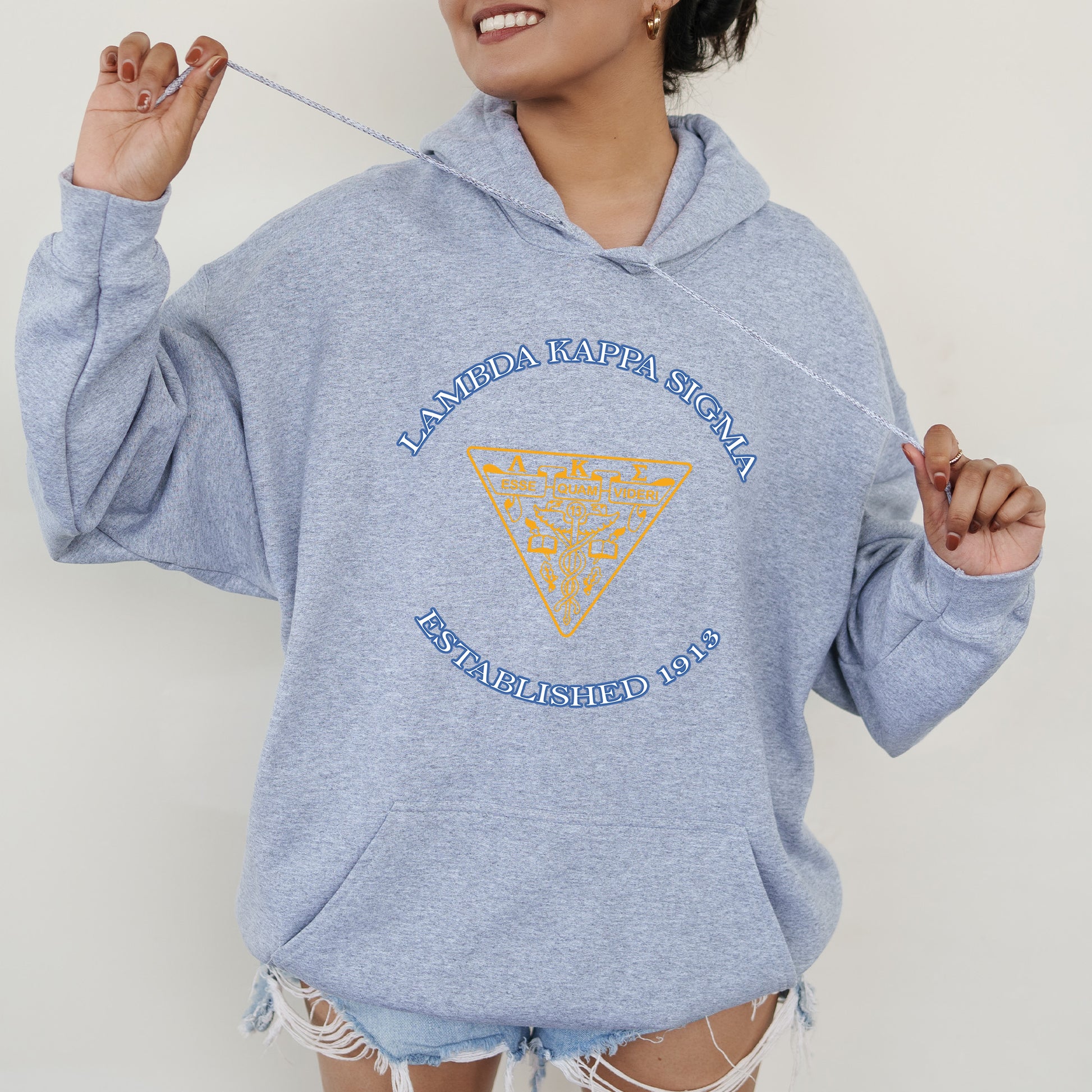 a woman in a blue hoodie holding a toothbrush