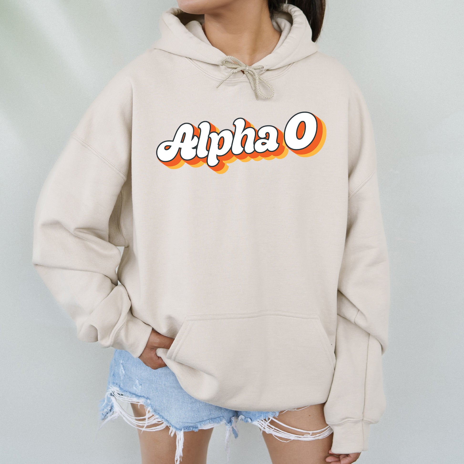 a woman wearing a white hoodie with the word alpha on it