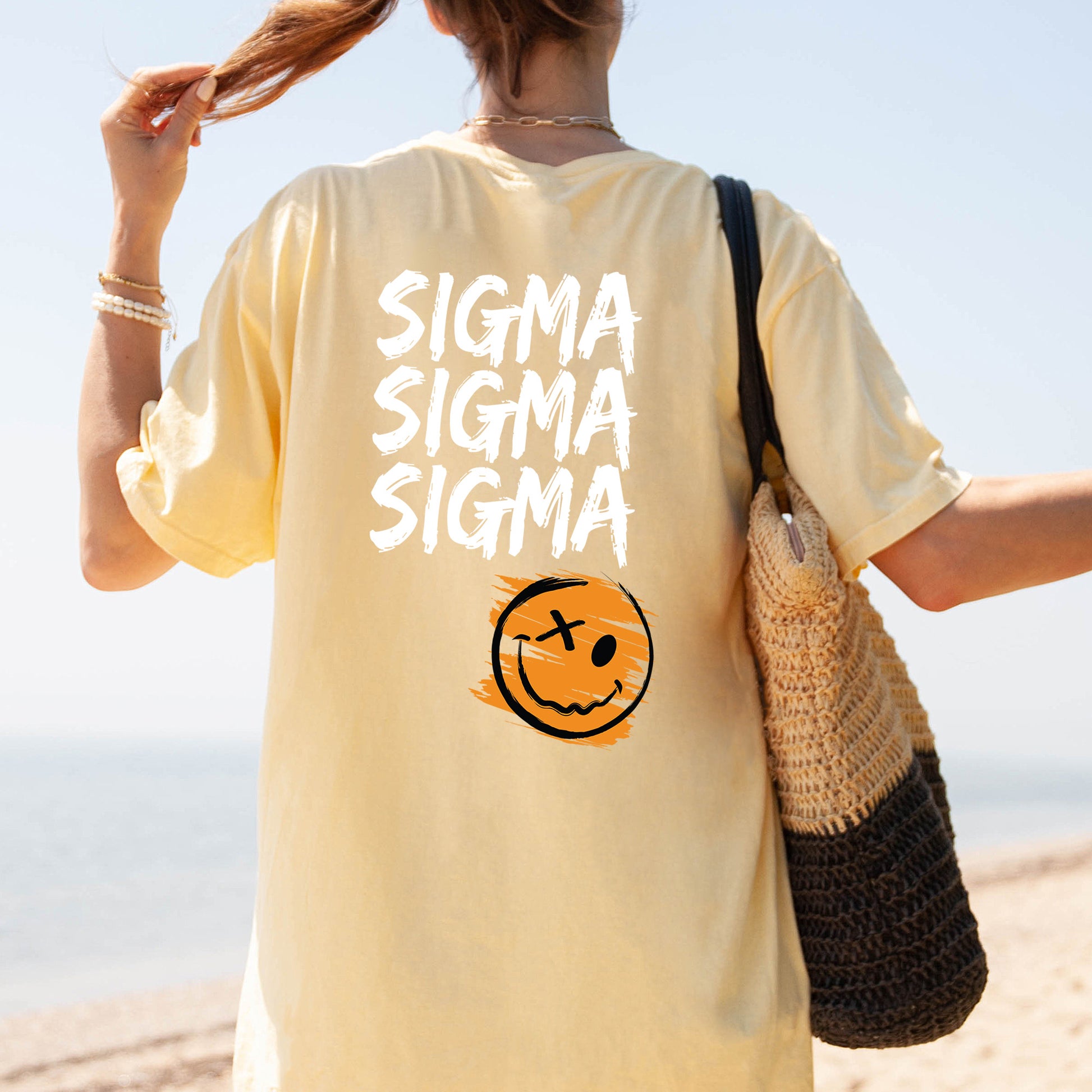 a woman walking on the beach with a smile on her shirt