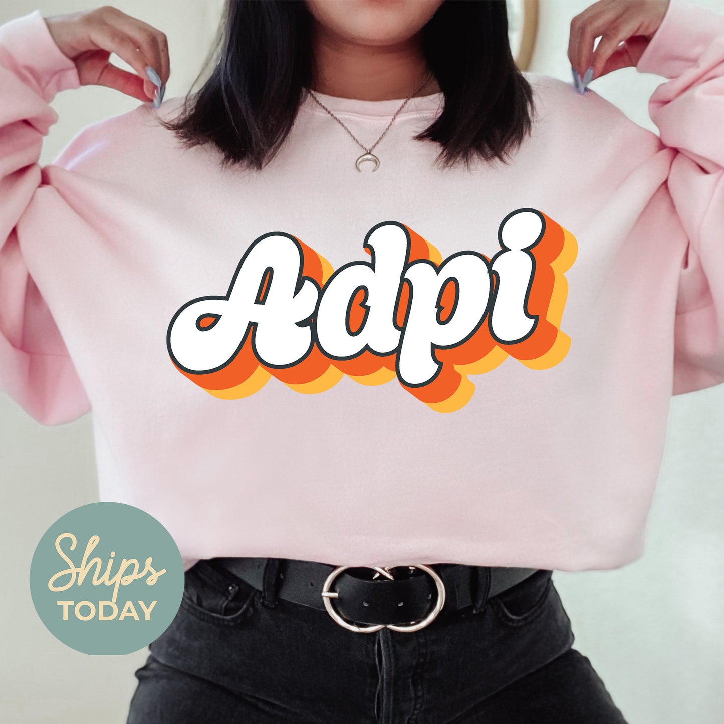 a woman wearing a pink sweatshirt with the word adpi printed on it