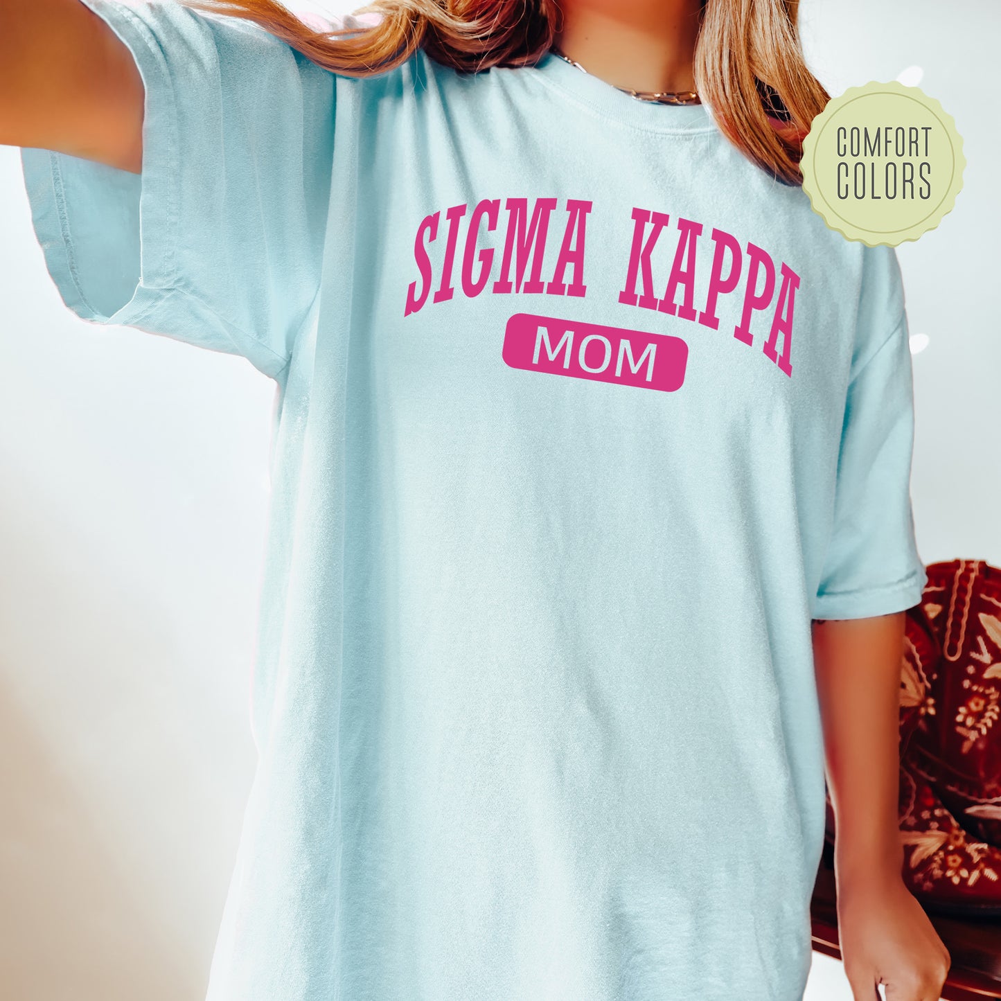 a woman wearing a light blue tshirt with pink lettering