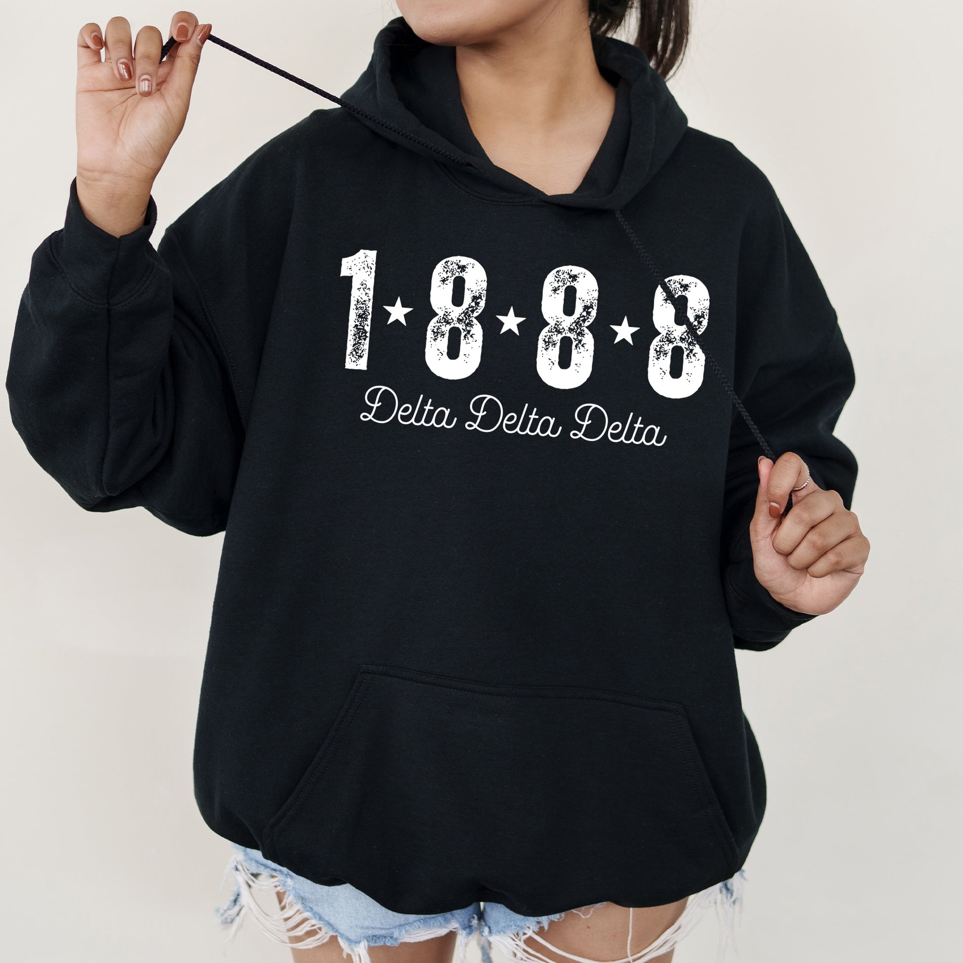 a woman in a black hoodie is holding a toothbrush