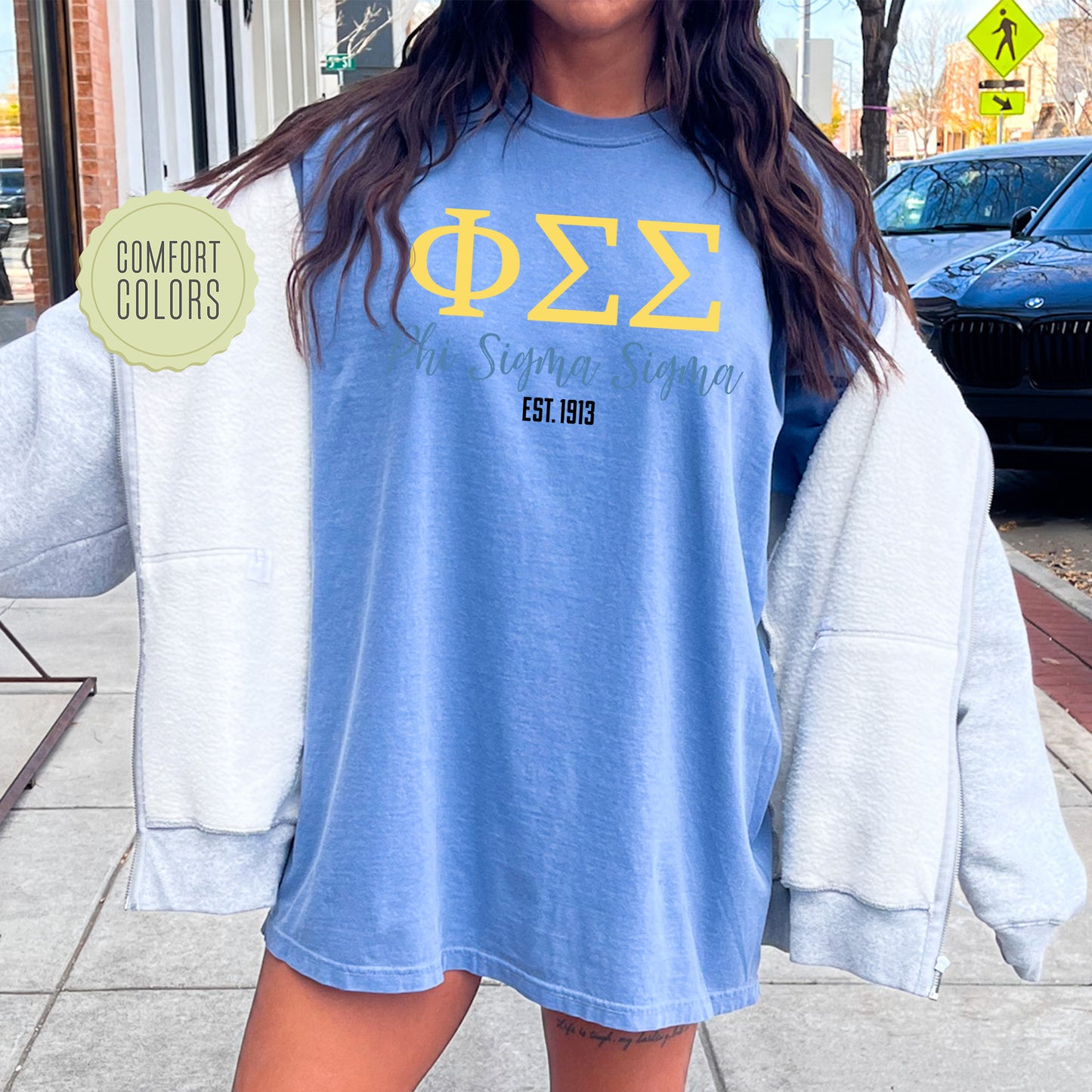 a woman standing on a sidewalk with a blue shirt