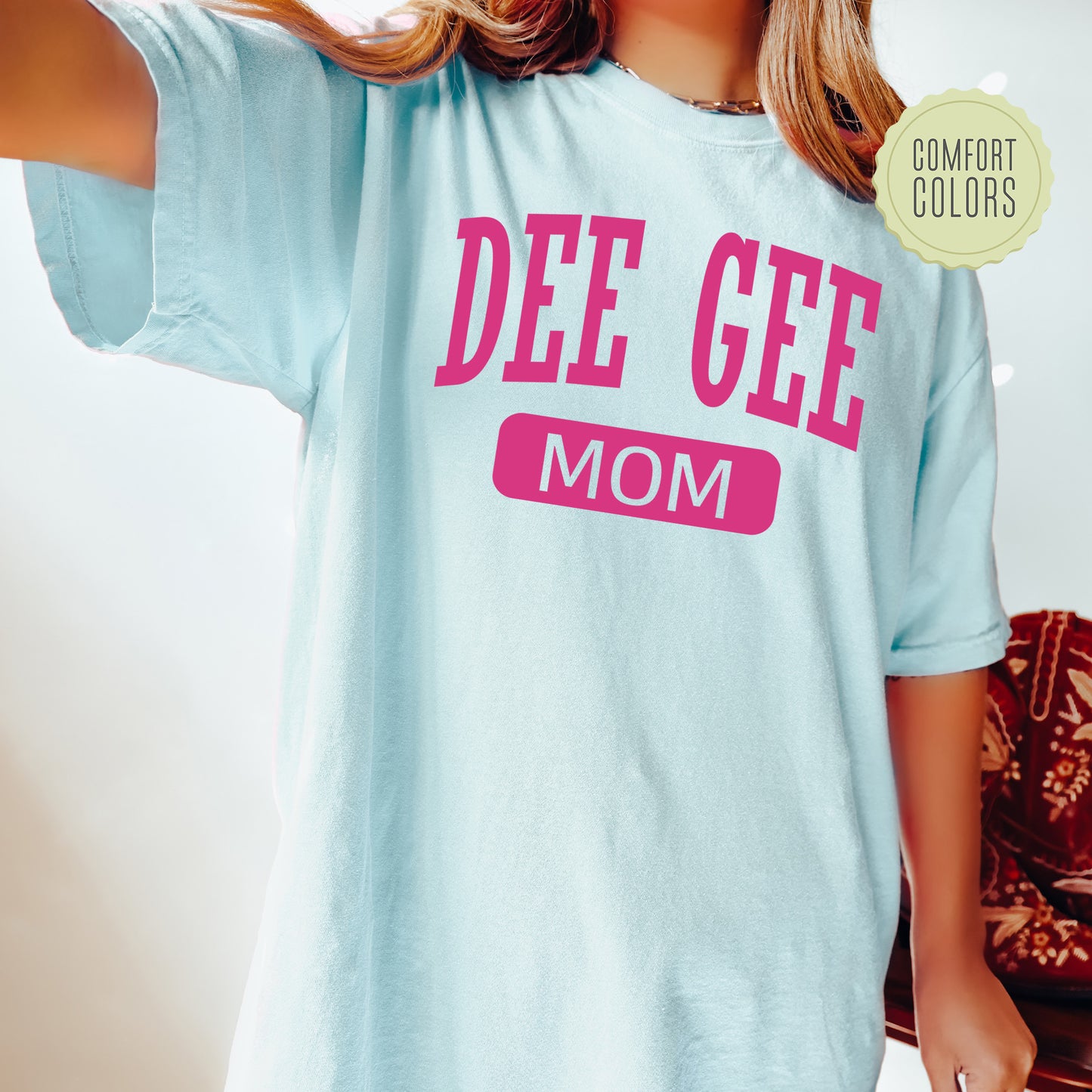 a woman wearing a blue tee shirt that says deee geee mom