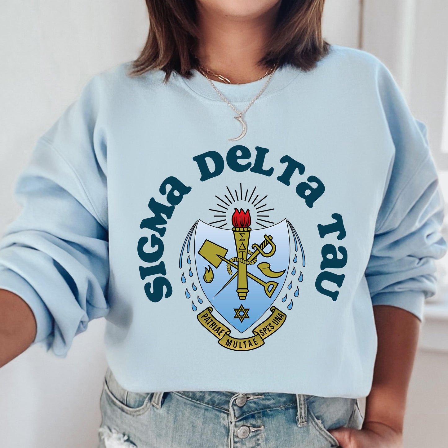 a woman wearing a blue sweatshirt with a cross on it