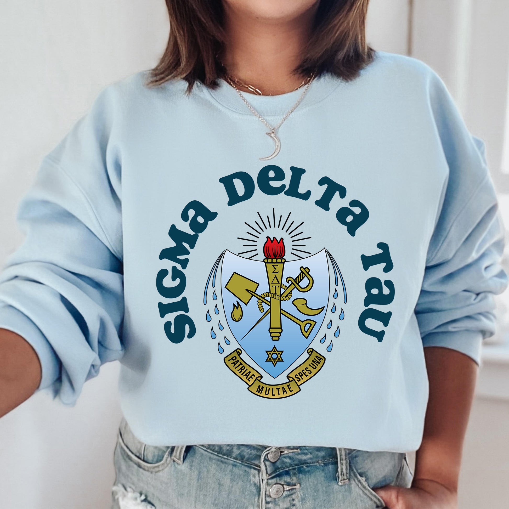 a woman wearing a blue sweatshirt with a cross on it
