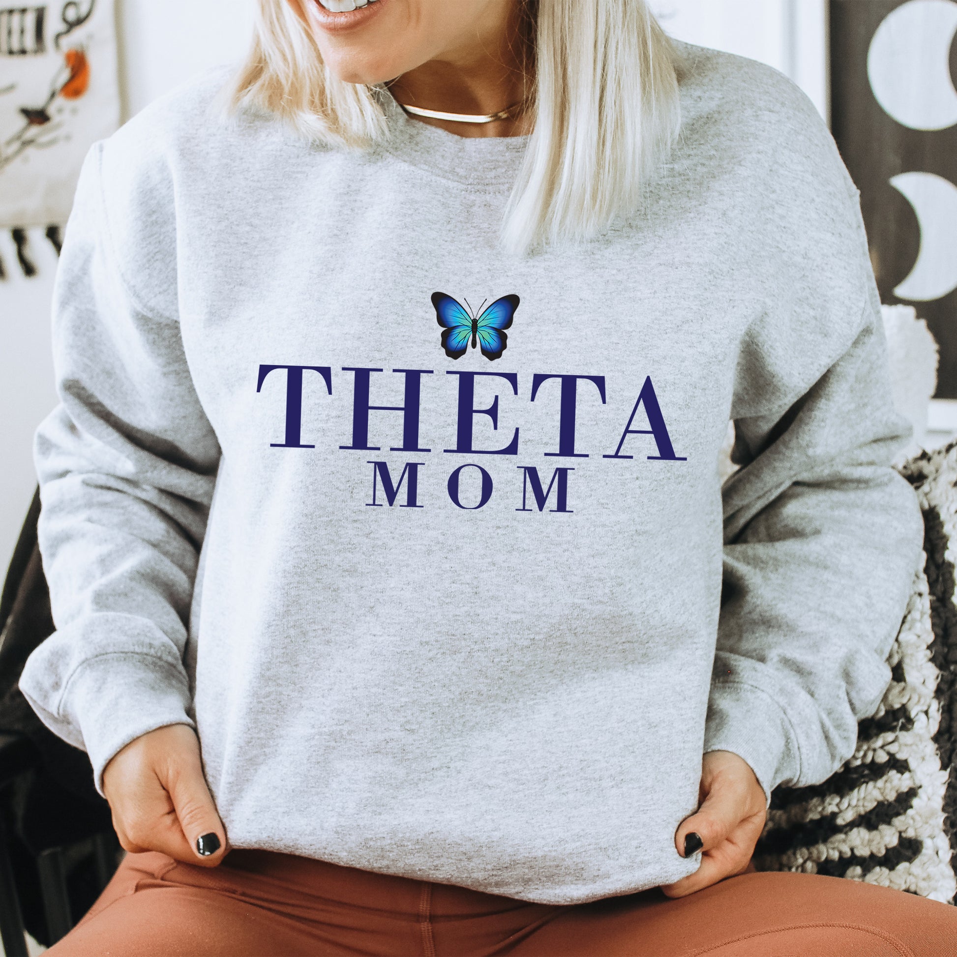 a woman wearing a sweatshirt that says thea mom
