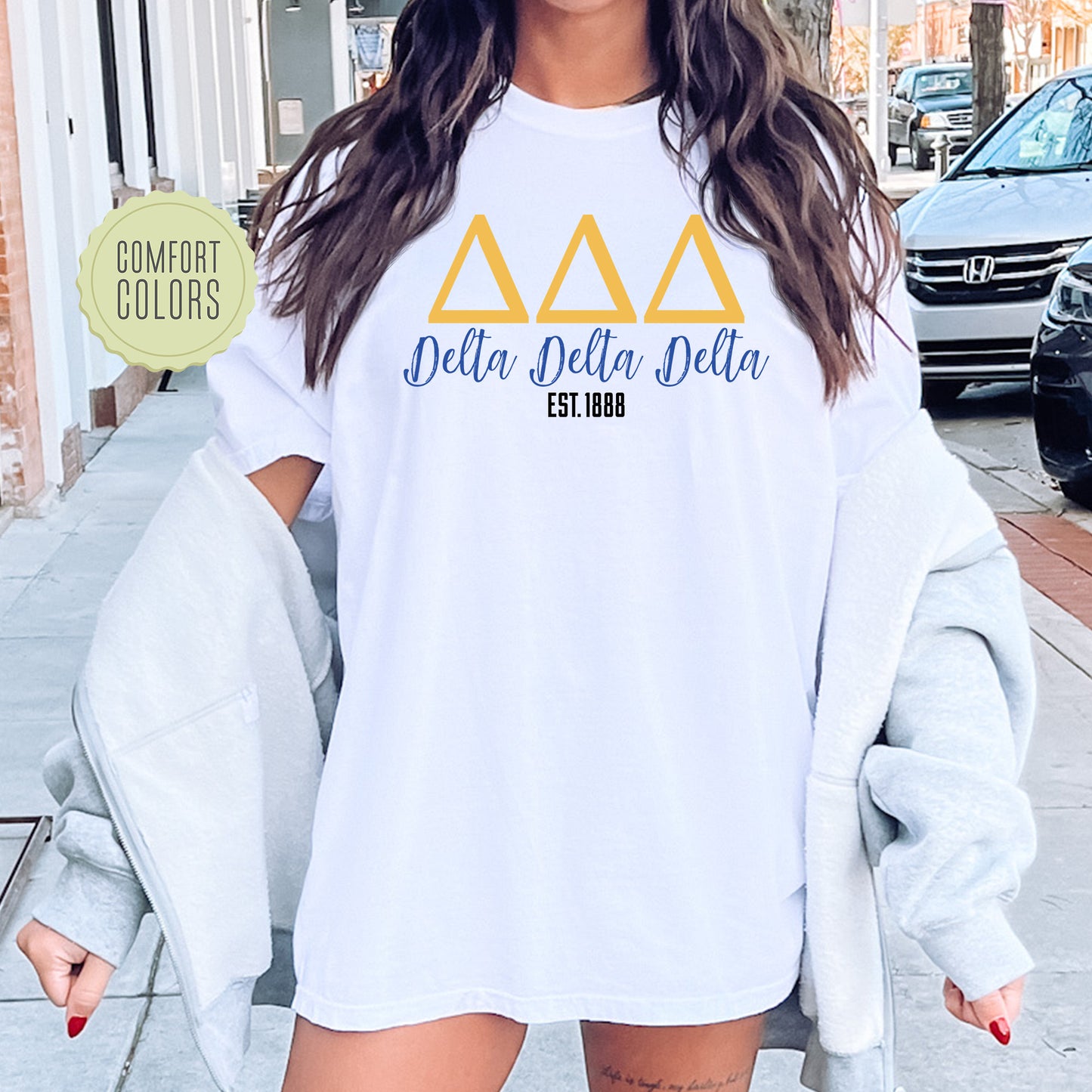 a woman wearing a white delta delta shirt