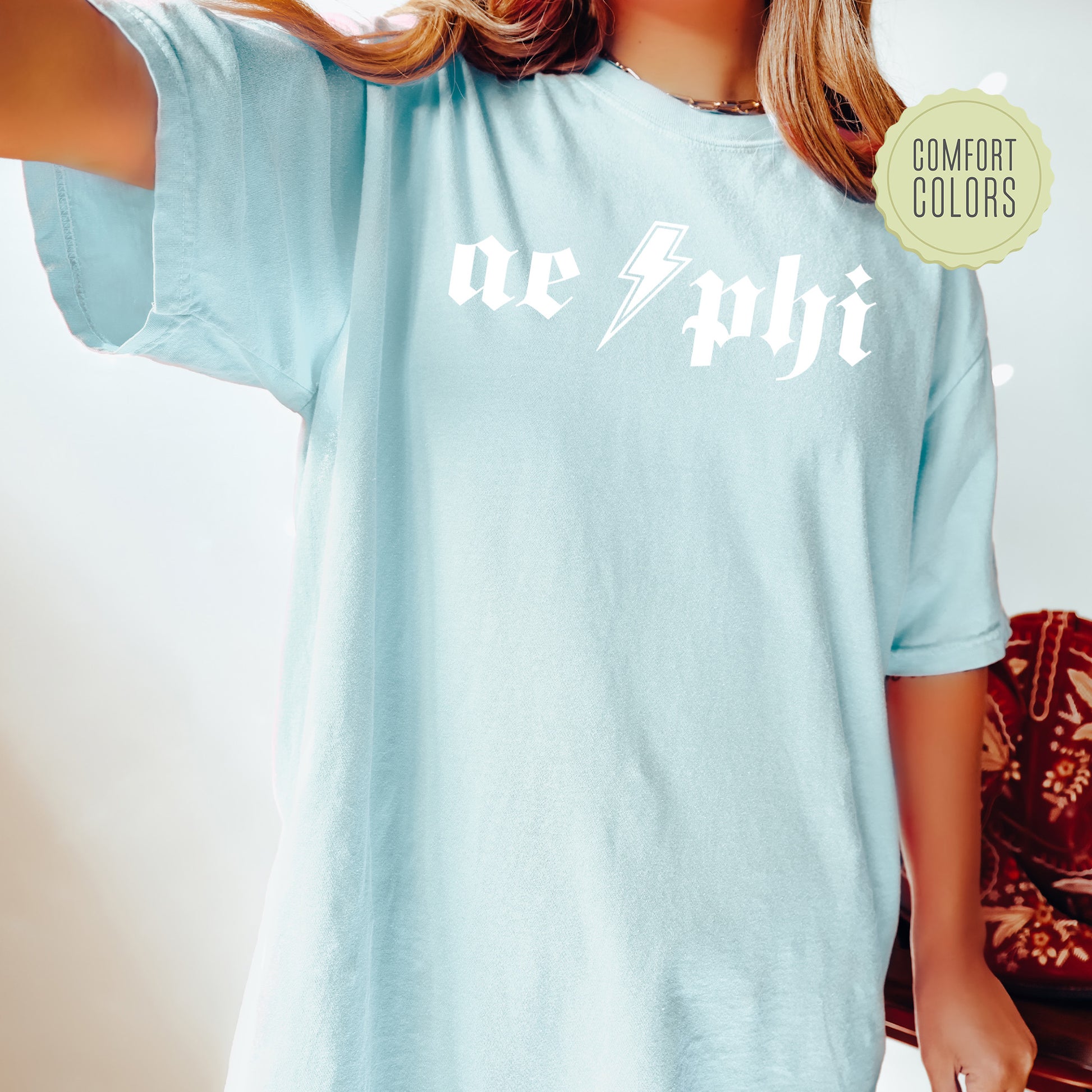 a woman wearing a light blue shirt with the word achi printed on it